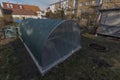 Exterior of empty greenhouse before spring with concrete walls and garden