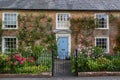 The exterior of an english cottage with flowers blooming in the front garden and sash windows, A typical english countryside Royalty Free Stock Photo