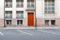 Exterior facade of an old stone building with a classic red wooden door and windows Royalty Free Stock Photo