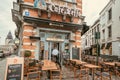 Exterior of historical bar with trademark name Leffe beer and outdoor cafe tables