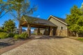 Exterior of a home with view of the paved driveway and pavilion at the entrance