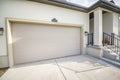 Exterior of a house with closed garage door and part of a porch entry with stairs