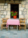 Exterior house with old chairs and table on stone street. Zarouhla village, Greece Royalty Free Stock Photo