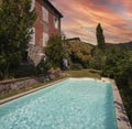 Exterior of Italian villa in Tuscany with swimming pool. Sunset view, romantic scenery Royalty Free Stock Photo