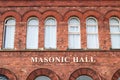 Exterior of Masonic Hall brick building showing sign in gold