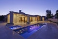 Exterior of modern home with swimming pool at dusk Royalty Free Stock Photo