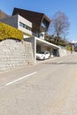 Exterior modern isolated villa, surrounded by nature. Iron and concrete cladding. Front road deserted