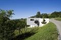 Exterior of a modern colored concrete house. A cube in the middle of the green. Royalty Free Stock Photo
