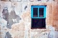 Exterior of an old abandoned cottage with broken blue wooden window frame Royalty Free Stock Photo