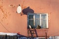 Exterior of old apartment house with wooden window, satellite dish and ragged paint in village Royalty Free Stock Photo