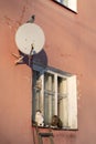 Exterior of old apartment house with wooden window, satellite dish and ragged paint in village Royalty Free Stock Photo