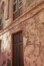 Exterior of an old building with peeling paint. Architecture details of an ancient, weathered rustic residential build