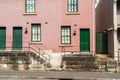 Exterior of old red brick townhouse with green doors