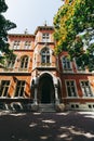 exterior of an old three story red brick building with white columns on entrance, beautiful stone windows surround, keystones and Royalty Free Stock Photo