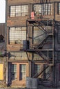 Exterior of an old warehouse building with brick, windows, fire escape