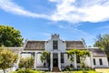 Exterior of an old white house in the style of the Dutch Cape architecture in Stellenbosch, Western Cape, South Africa