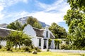 Exterior of an old white house in the style of the Dutch Cape architecture in Stellenbosch, Western Cape, South Africa