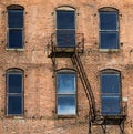 Red Brick Building with Windows and Fire Escape Royalty Free Stock Photo