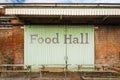 Exterior of rustic food hall building with large wooden barn doors and old red brick walls. Royalty Free Stock Photo