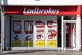 Exterior shot of Ladbrokes Gambling Betting Shop on High Street with adverts in window Royalty Free Stock Photo