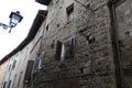 Exterior shot of a medieval stone building with old wall lamp in Tuscan village, Italy Royalty Free Stock Photo