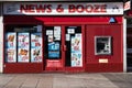 Exterior shot of News and Booze Off Licence Liquor Store showing company name, slogan signage, logo and atm cash machine