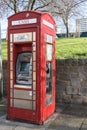 Exterior shot of a telephone kiosk on the pavement with ATM cash point built in. Modern retro design