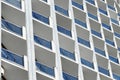 Exterior of a skyscraper building with blue windows and concrete partitions. Industrial urban background with repeating texture.