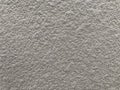 An Exterior textured painted outside of the highrise building with beige color and looking like grey and making a rough undulating