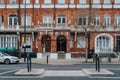 Exterior or traditional red brick buildings with white window frames in Kensington and Chelsea, London, UK