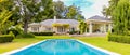 Exterior of Upmarket wealthy suburban mansion house with landscaped garden and swimming pool Royalty Free Stock Photo