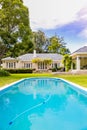 Exterior of Upmarket wealthy suburban mansion house with landscaped garden and swimming pool Royalty Free Stock Photo