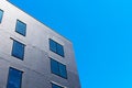 Exterior view of building under construction. The wall is covered with black insulation material. Blue sky