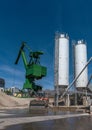 Exterior view of a cement factory with green crane Royalty Free Stock Photo
