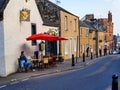 Exterior view down the street of traditional puglesian Italian restaurant Mama Mia, with seated female customer