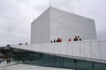 Oslo, Norway, September 2022: Exterior view of the modern Oslo Opera House building, with people walking on the roof. Royalty Free Stock Photo