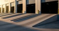 Exterior view of multiple loading dock bays featuring concrete access ramps bathed in sunlight. Royalty Free Stock Photo