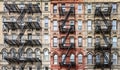 Exterior view of New York City style architecture apartment building with windows and fire escapes Royalty Free Stock Photo