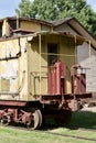 Exterior view of an old obsolete yellow and red 19th Century railroad train caboose