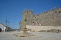 Exterior view of pillory with religious cross and the castle of Trancoso, medieval building with fortress wall, family of tourists