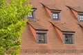 Exterior view of a traditional red-tiled roof house with ornate window frames