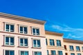 Exterior view of typical new medium rise multifamily residential building under blue sky. The buildings could be occupied as