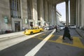 Exterior view of yellow taxi cab and walking business man in front of the 30th Street Station, a national Register of Historic Pl