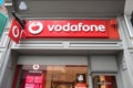 Exterior of Vodafone mobile phone and technology shop store showing sign, signage, logo and branding above top of entrance