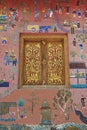 Exterior wall with beautiful mosaic and gold painted window of the pavilion at Xieng Thong temple in Luang Prabang, Laos. Royalty Free Stock Photo