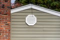 Exterior wall of suburban house, old brick chimney, attic fan exhaust vent on wall Royalty Free Stock Photo