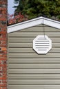 Exterior wall of suburban house, old brick chimney, attic fan exhaust vent on wall Royalty Free Stock Photo