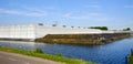 The exterior whitewashed greenhouse glass facade of commercial greenhouse with closed water basin and water channel. the Royalty Free Stock Photo