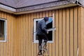 Exterior window finishing with metal jambs and mouldings, construction worker working standing on stepladder.