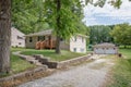 Exteriors of a small rural house with wooden stairs, green lawn. a trail and trees around Royalty Free Stock Photo